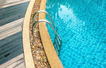 Swimming pool with glittering tiles and wooden deck